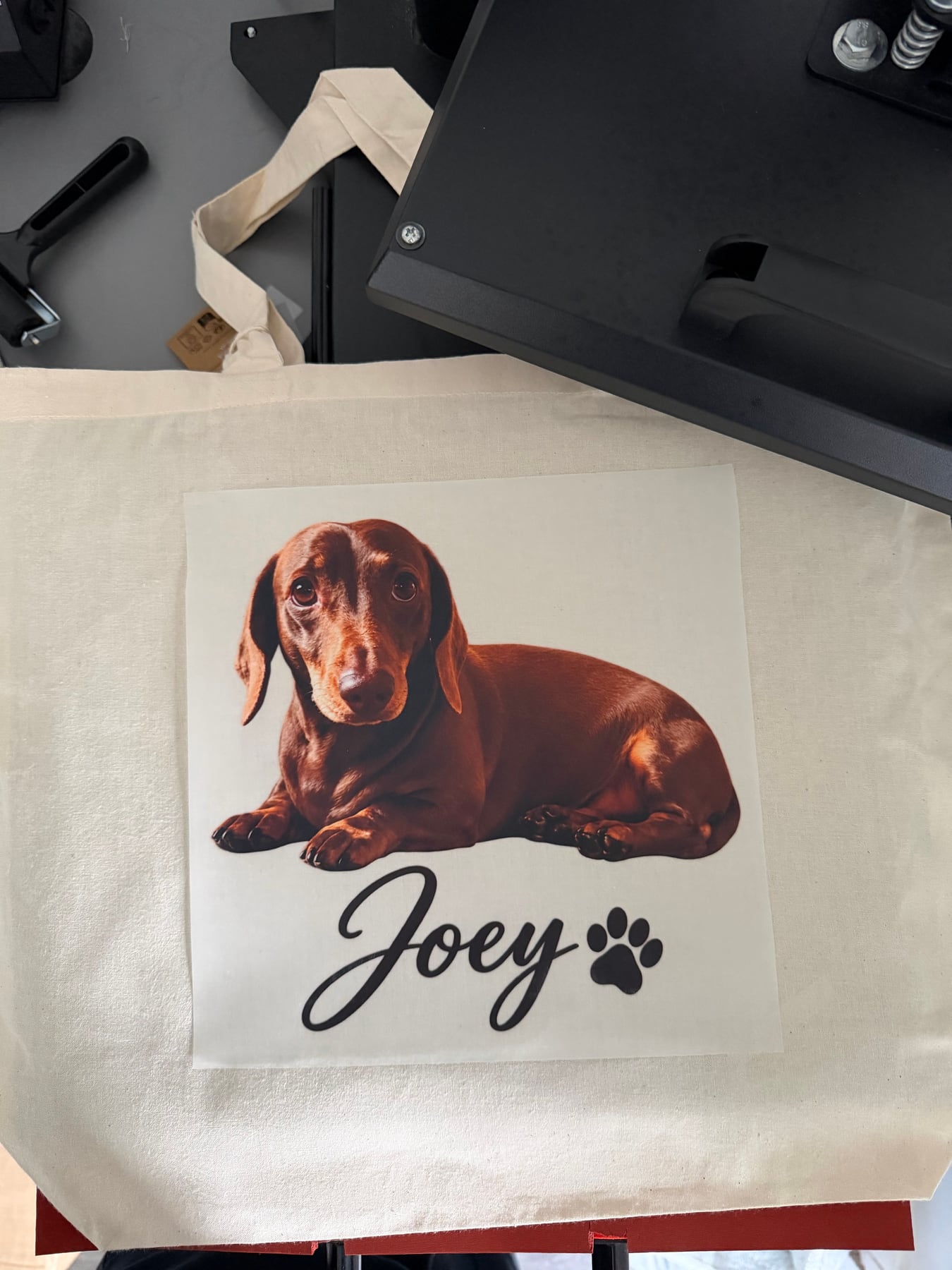 Joey dachshund transfer positioned on a natural tote before pressing