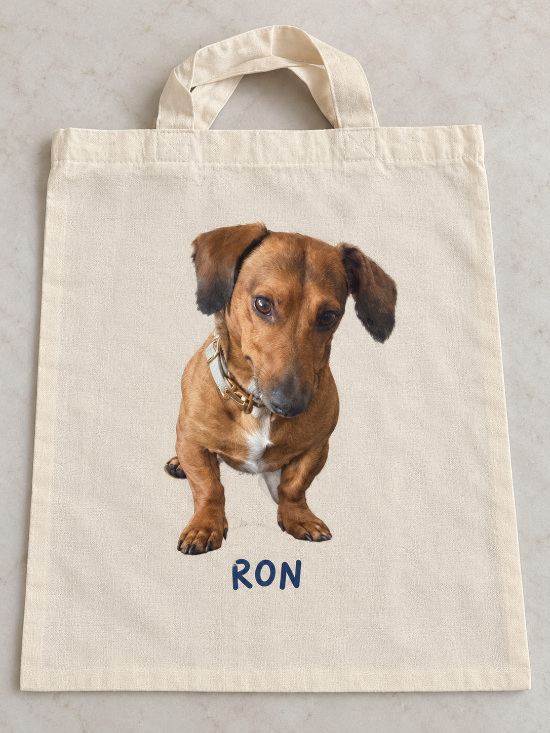 Ron design mock-up on a lightweight cream soft tote with short handles
